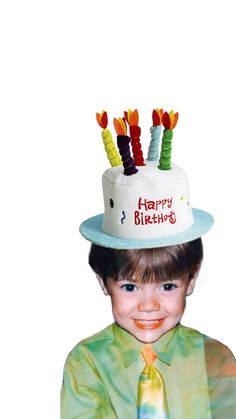 a young boy wearing a birthday hat with candles on it