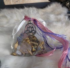 a bag filled with various items sitting on top of a white fur covered floor next to a pile of rocks