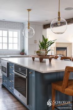 a kitchen with an island and two hanging lights over it's stove top oven