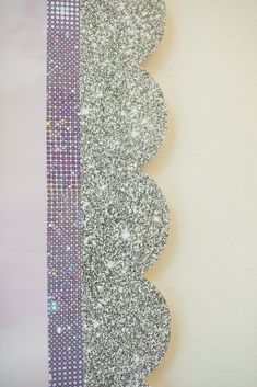 a white wall with some silver and purple glitters on it's side,