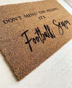 a brown door mat with the words football song written on it and don't mind the