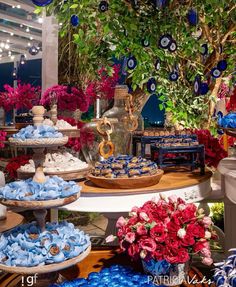 an assortment of desserts on display at a wedding or baby shower party with blue and red flowers