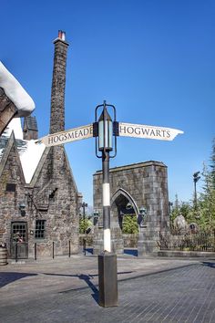 a street sign in front of a stone building