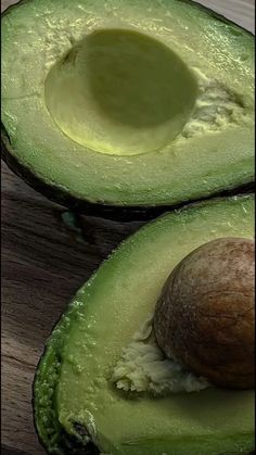 an avocado cut in half on a wooden table