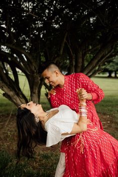 Manisha and Akash stunning in matching red and gold outfits by Harleen Kaur. Designed in a lightweight bold red cotton with a gold foil pattern throughout, perfect for any Indian wedding weekend! Manisha is wearing a tiered red Milly Lehenga Skirt & Akash is wearing a long sleeve red Sumeet Kurta. Explore outfits in red & find Manisha & Akash's client diary at www.harleenkaur.us South Asian Outfits