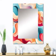 a bathroom mirror sitting on top of a wooden counter next to a vase and potted plant