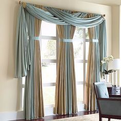 an elegant dining room with blue and beige drapes