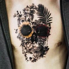 a man's chest with a sunflower and flower skull tattoo on the side