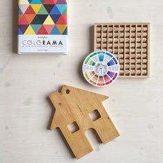 a wooden house next to a box of colorama and some other crafting supplies