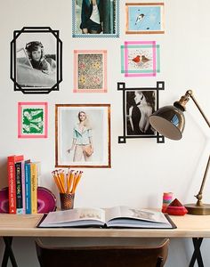 a desk with books, magazines and pictures on the wall