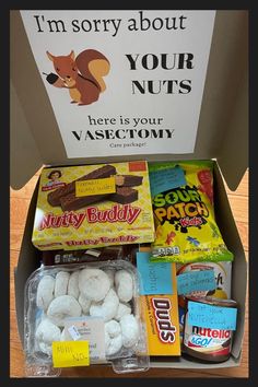 a box filled with lots of different types of food and candys on top of a wooden table