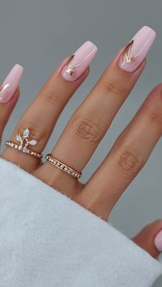 a woman's hand with pink manies and gold rings