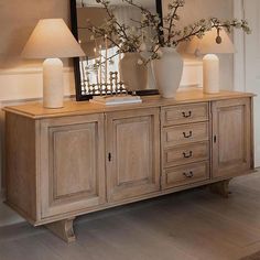 a table with two lamps and a mirror on top of it next to a dresser