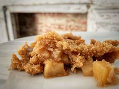 a white plate topped with food covered in crumbs on top of a table