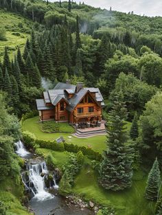 an aerial view of a log cabin in the woods with a waterfall running through it