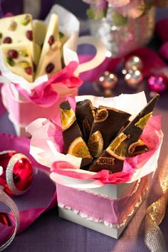 there are many pieces of chocolate in the box on the table next to some decorations