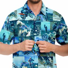 a man wearing a blue shirt with pictures of motorcyclists on it is holding his hands in front of his chest