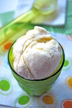 a green bowl filled with ice cream on top of a table