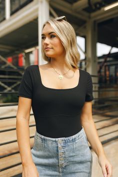 Close up of model wearing the Kendra Square Neck Padded Bodysuit in black. This is a bodysuit with a square neckline Modern Black Stretch Bodysuit, Casual Black Short Sleeve Bodysuit For Night Out, Black Fitted Short Sleeve Bodysuit, Fitted Black Modern Bodysuit, Modern Black Fitted Bodysuit, Modern Fitted Black Bodysuit, Casual Black Elastane Bodysuit, Black Square Neck Bodysuit For Summer, Fitted Black Bodysuit With Square Neck