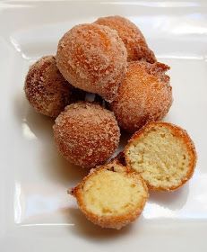 some sugared doughnuts are on a white plate