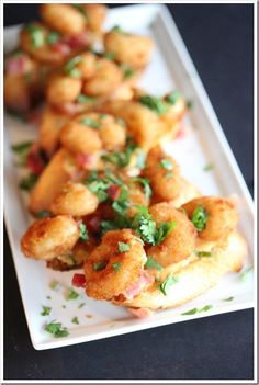 fried food on a white plate with parsley sprinkled around the edges and garnished with cilantro