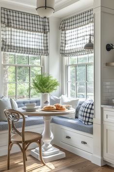 a breakfast nook in the corner of a kitchen with blue and white checkered curtains