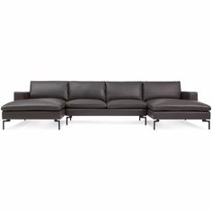 a black leather sectional sofa sitting on top of a white floor