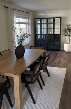 a dining room table with chairs and a vase on it