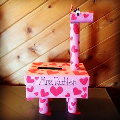 a pink giraffe made out of cardboard with hearts on it's sides