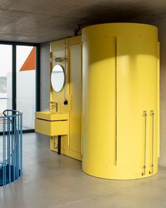 a large yellow toilet sitting in the middle of a room next to a round window