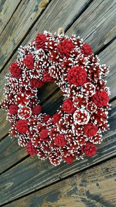 a red and white wreath on a wooden fence