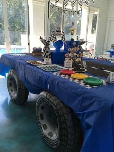 a blue table topped with lots of plates and cupcakes on top of it