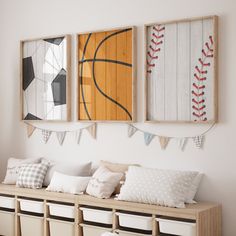 three sports themed paintings hang on the wall next to a bench with pillows and storage bins