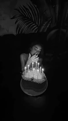 a woman blowing out candles on a cake with her face in the middle of it