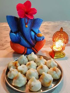 a plate full of dumplings next to a blue elephant figurine on a table