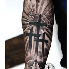 a man with a cross tattoo on his arm