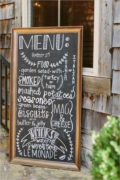 a menu sign on the side of a building next to a potted green plant