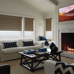 a living room filled with furniture and a fire place in front of a tv mounted on the wall