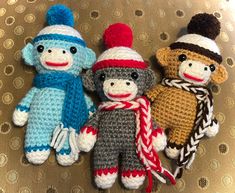 three crocheted stuffed animals sitting next to each other on top of a table