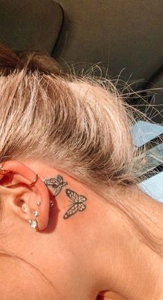 a woman with tattoos on her ear and behind the ear