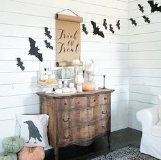 a dresser with halloween decorations on it and a trick or treat sign hanging from the wall