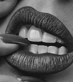 a black and white photo of a woman's mouth with her nails on it