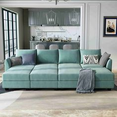 a living room filled with furniture next to a kitchen