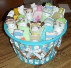 a blue basket filled with baby items on top of a wooden floor next to a table