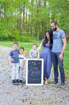 a family posing for a photo with a chalkboard sign