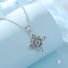 a silver necklace with a blue stone in the center