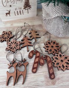 wooden keychains with reindeer and snowflakes on them next to a christmas card