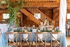 the table is set with blue linens and greenery for an elegant wedding reception