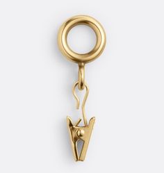 an image of a gold charm with a cat on it's back and a hook in the middle