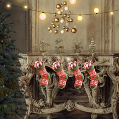 christmas stockings hanging from a mantle in front of a fireplace with ornaments and lights on it